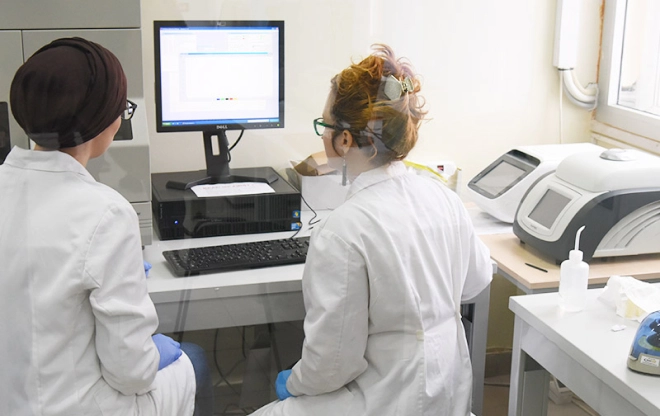 Students in lab coats using laboratory instruments
