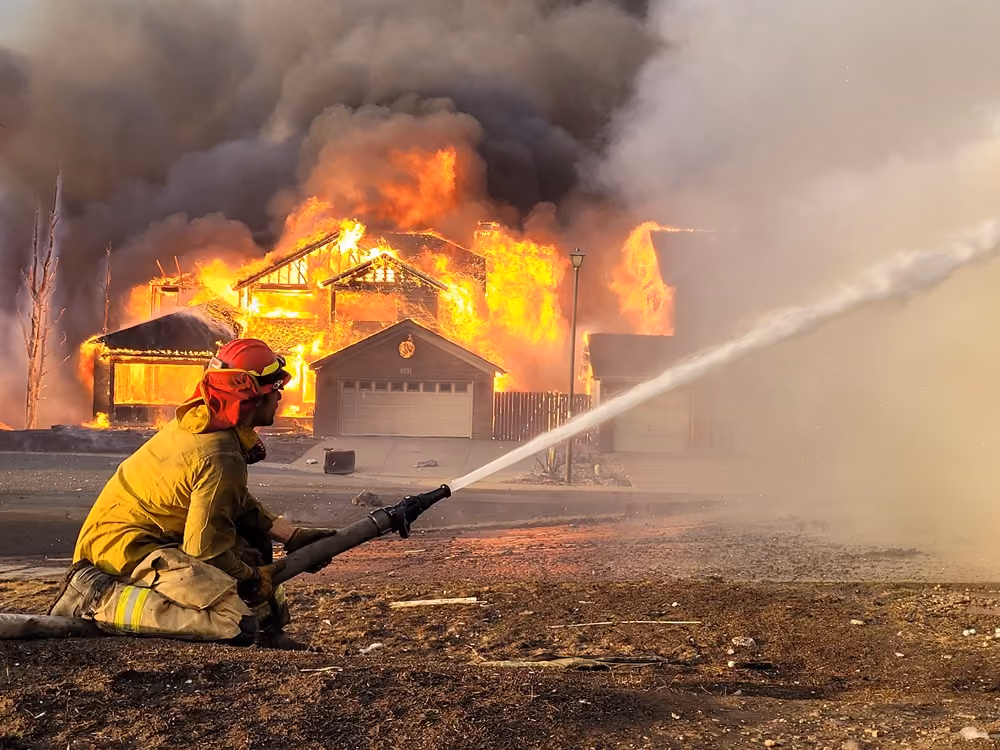 Firefighter in wildland gear working a grass fire