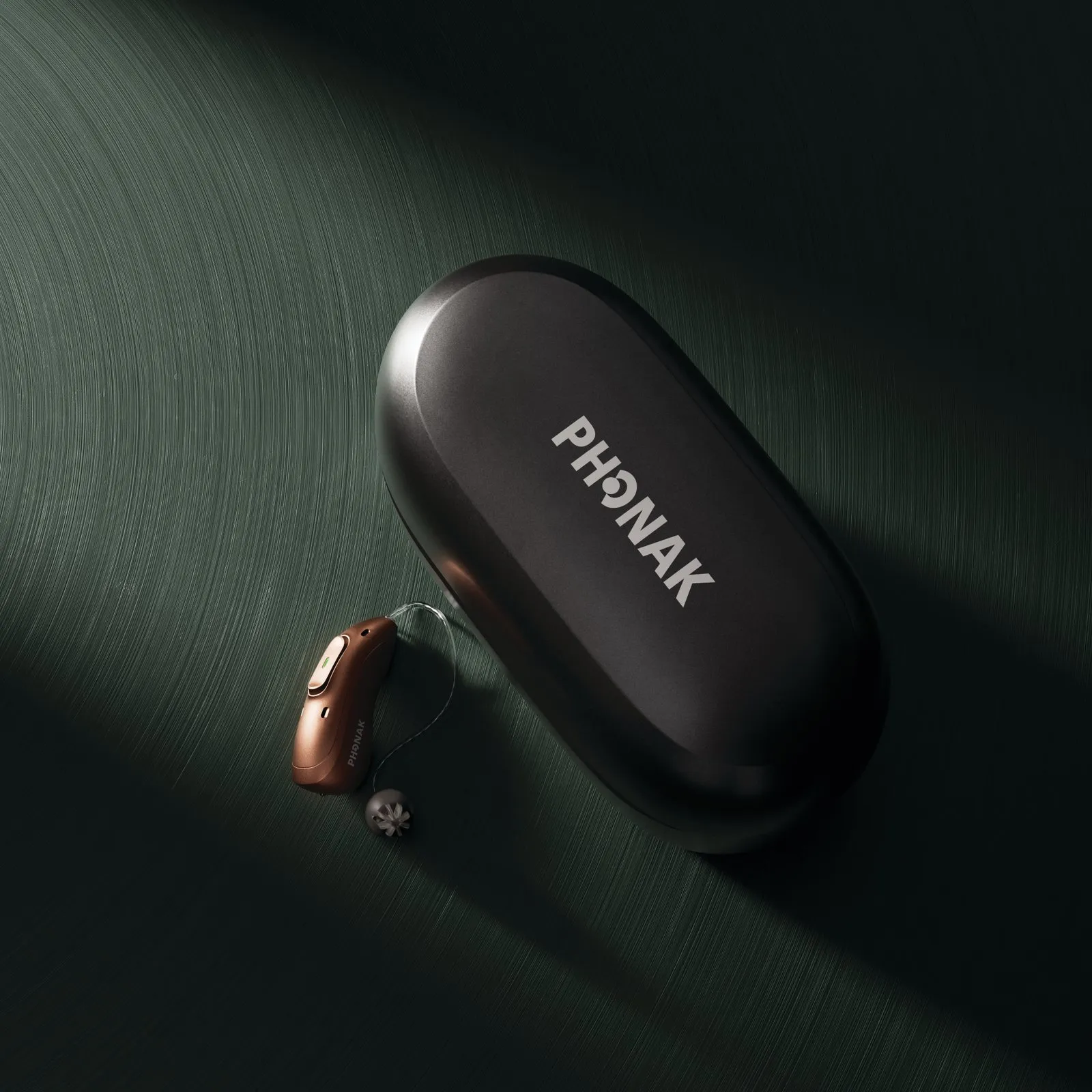 Phonak-Hörgerät mit Akku neben seinem Ladeetui