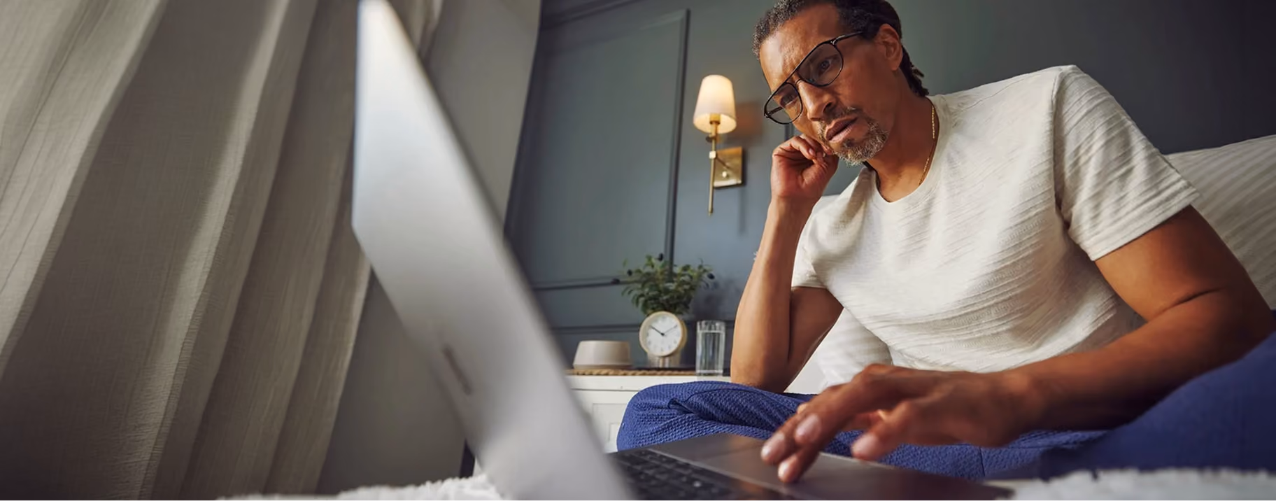 Man in glasses reviewing an insurance billing question on his laptop.