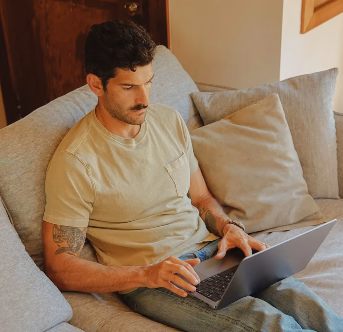 Man using a laptop at home with an AI chat assisting with an insurance claim and scheduling an inspection.