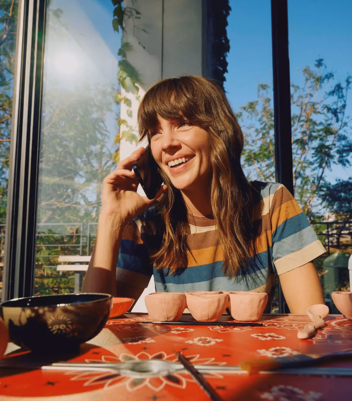 Woman looking at her phone with chat notifications showing a billing dispute being escalated and transferred to tier-2 support.