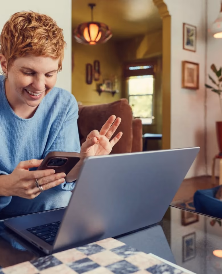 Woman using her phone beside a laptop with a Liberate launch notification