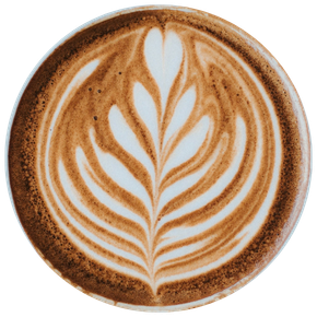 Tasse de café au lait vue de dessus avec un dessin de latte art en forme de feuille blanche sur la surface mousseuse du café.