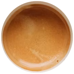 Vue de dessus d'une tasse d'espresso avec une couche de crème beige clair sur le dessus.