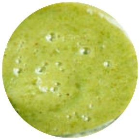Gros plan d'un smoothie vert lisse et épais, probablement à base d'épinards ou d'autres légumes verts.