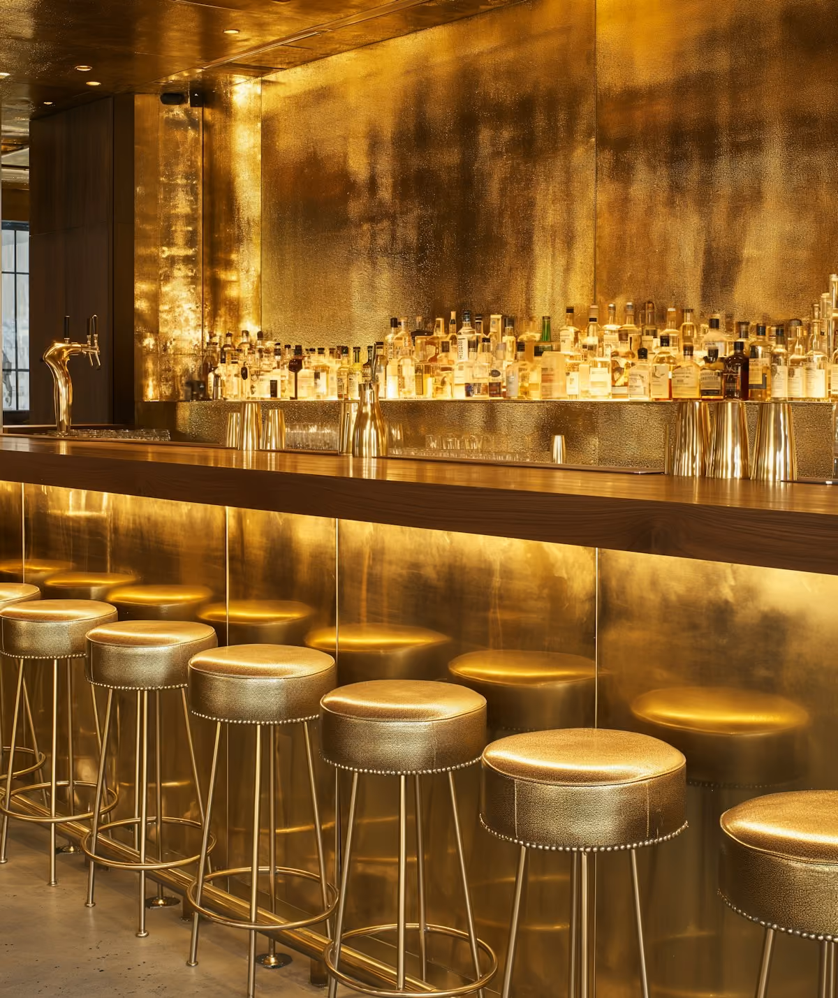 Brass bar with gold stools and a golden back wall