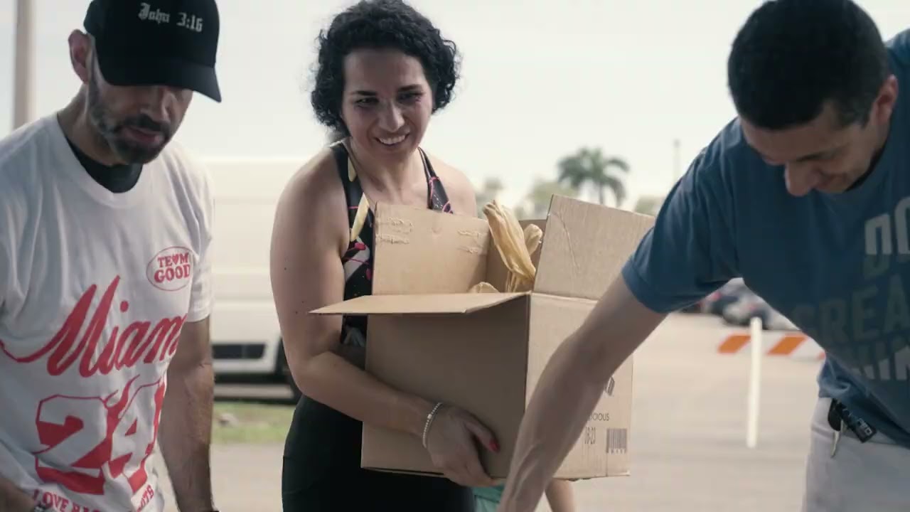 Volunteers carrying a box of food during a Good Neighbor Days distribution in Miami