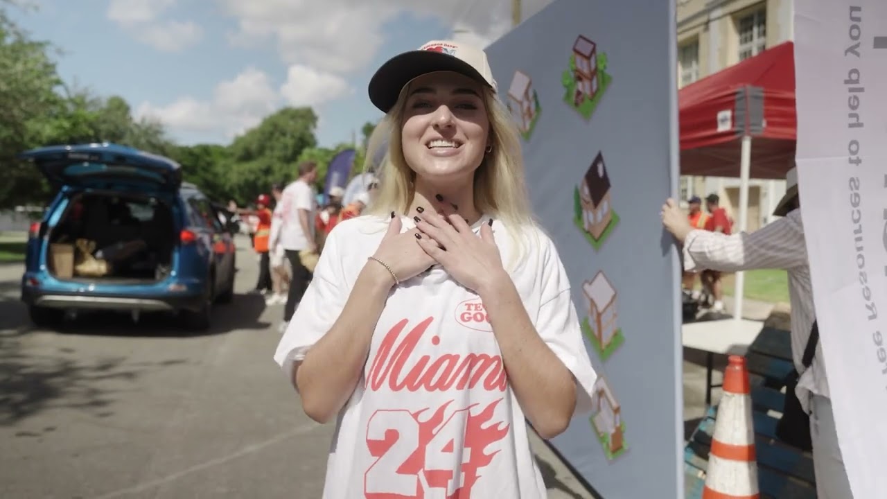 A smiling volunteer in a Miami shirt at a Good Neighbor Days event