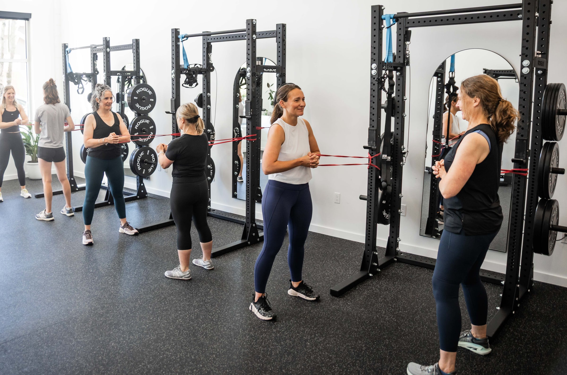 Women doing resistance band exercises on the training floor at Women's Strength Collective