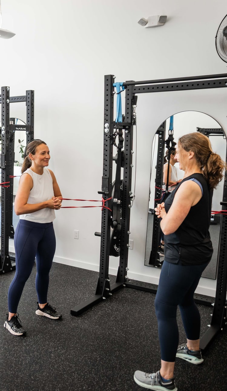Women doing resistance band exercises on the training floor at Women's Strength Collective