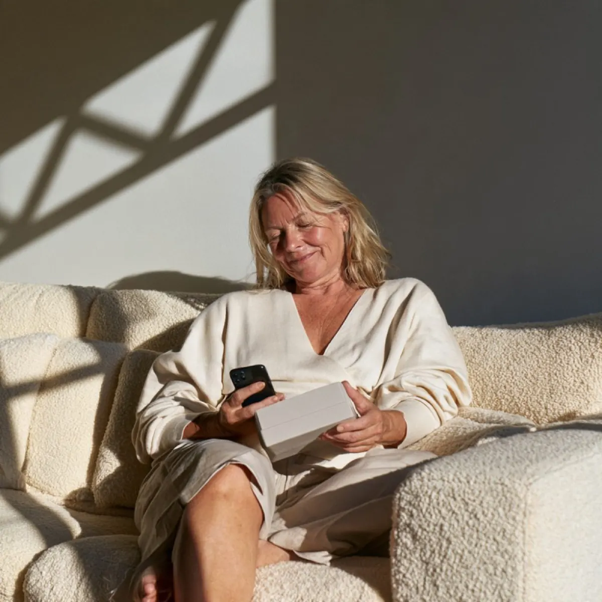 Kvinna i soffan som använder mobilen