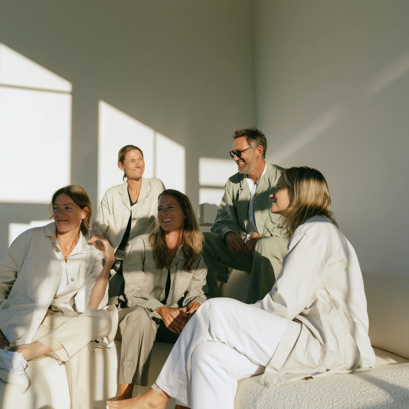 Grupp människor i ljusa kläder samlade i en soffa