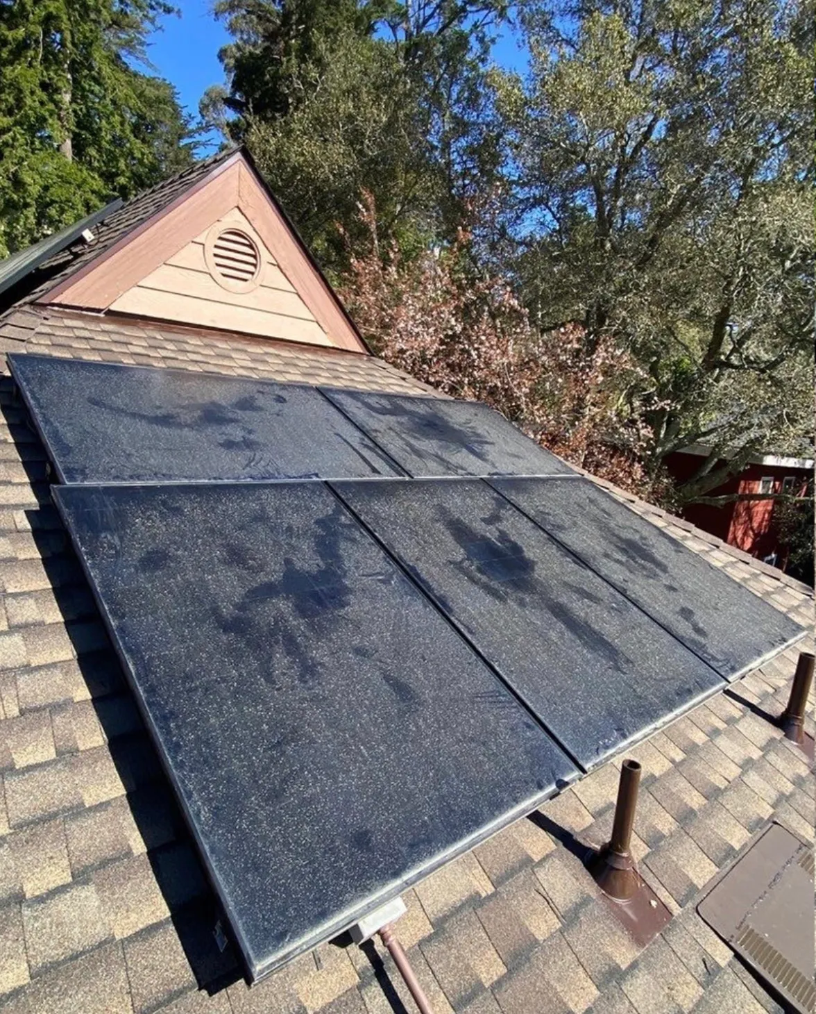 Rooftop solar panels covered in dust and water spots before cleaning