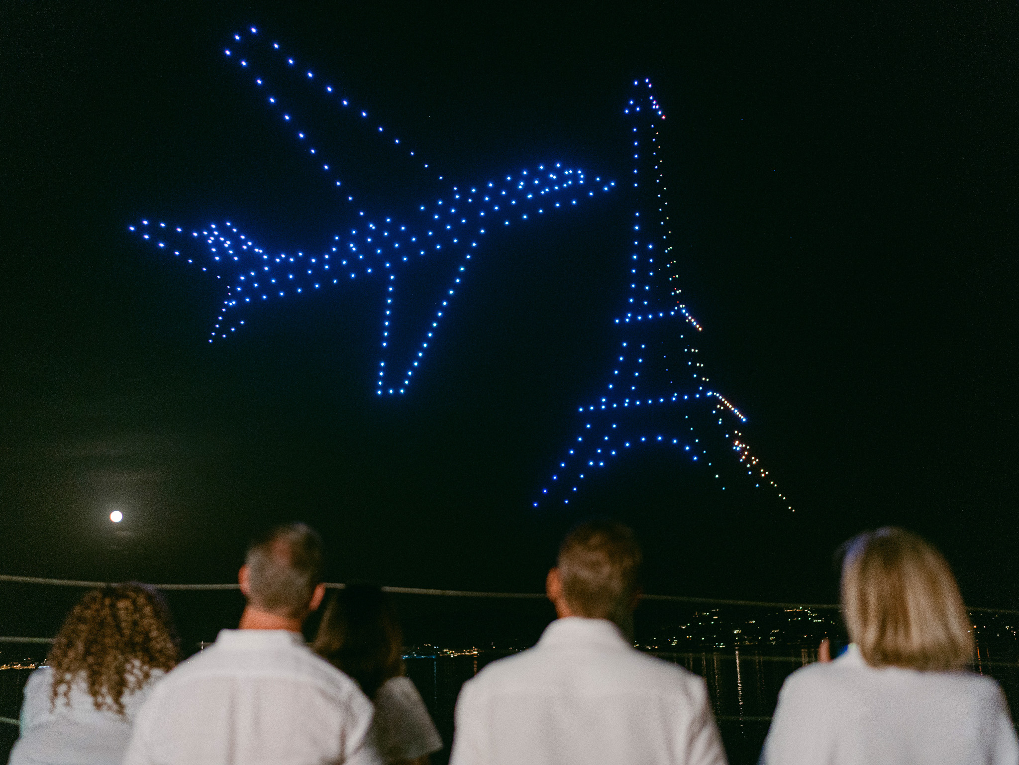 Un avion et la tour Eiffel dessinés par les drones au-dessus des invités d’un mariage