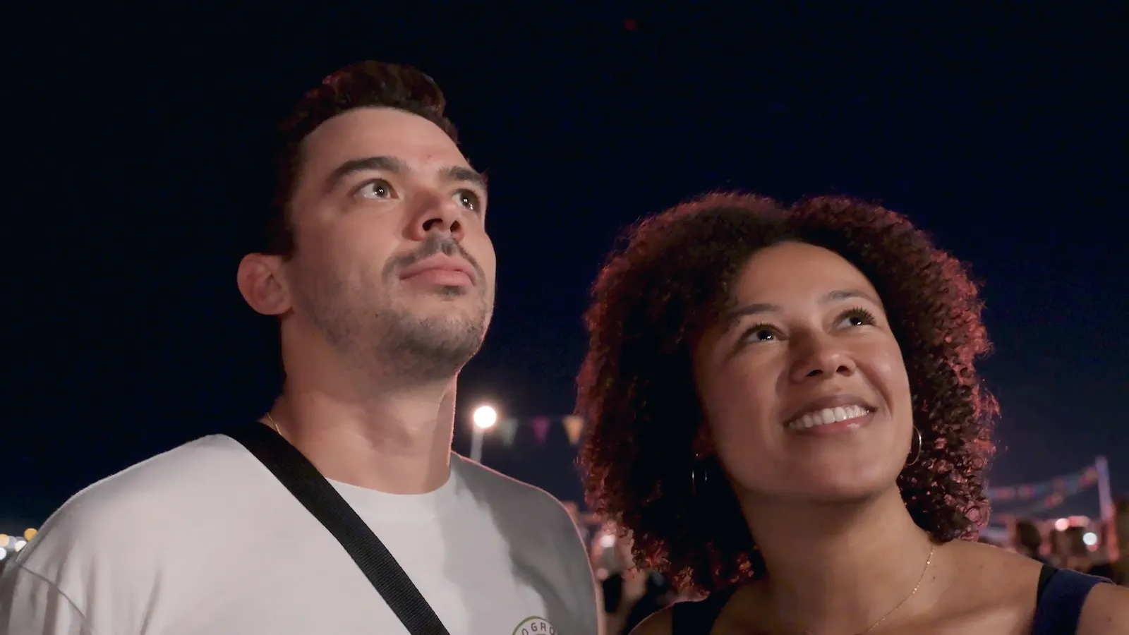 Des spectateurs émerveillés regardent un spectacle de drones lors d’une fête en ville