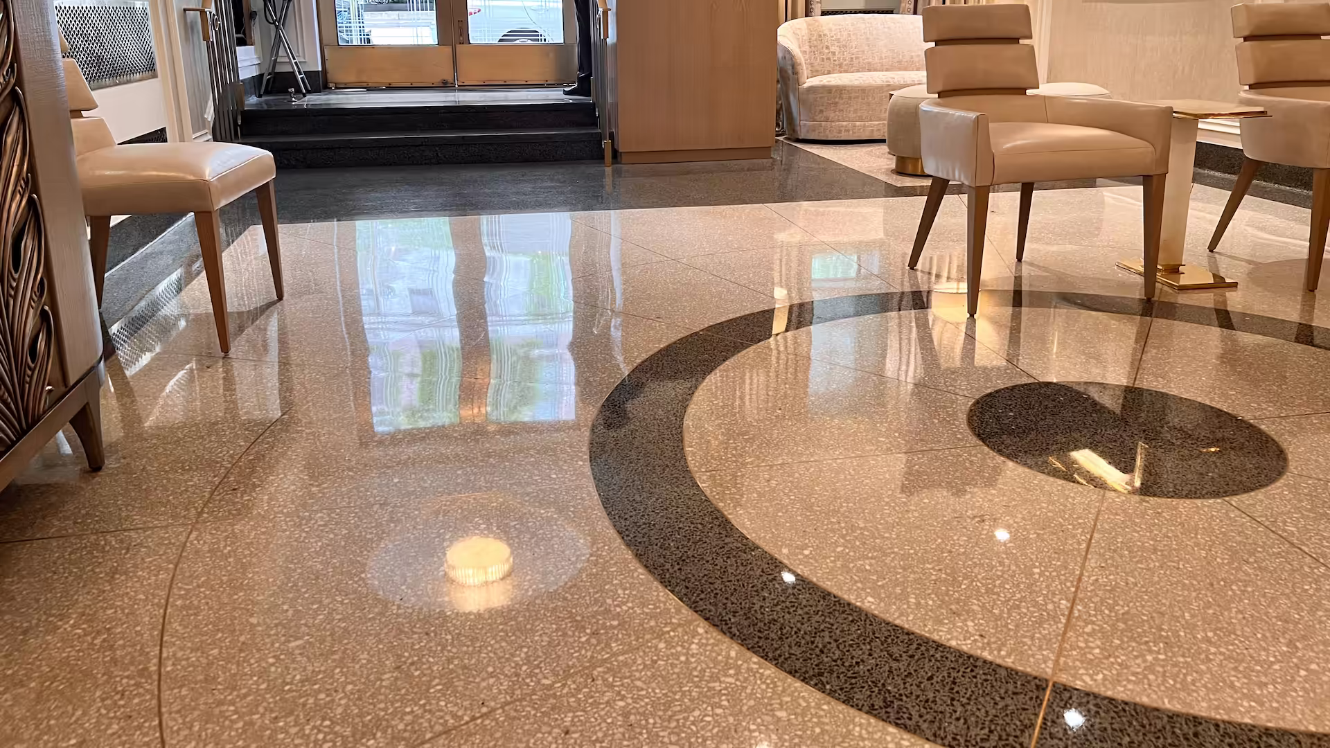 Custom epoxy terrazzo flooring and travertine walls in the Shore Towers elevator lobby in Astoria, New York.