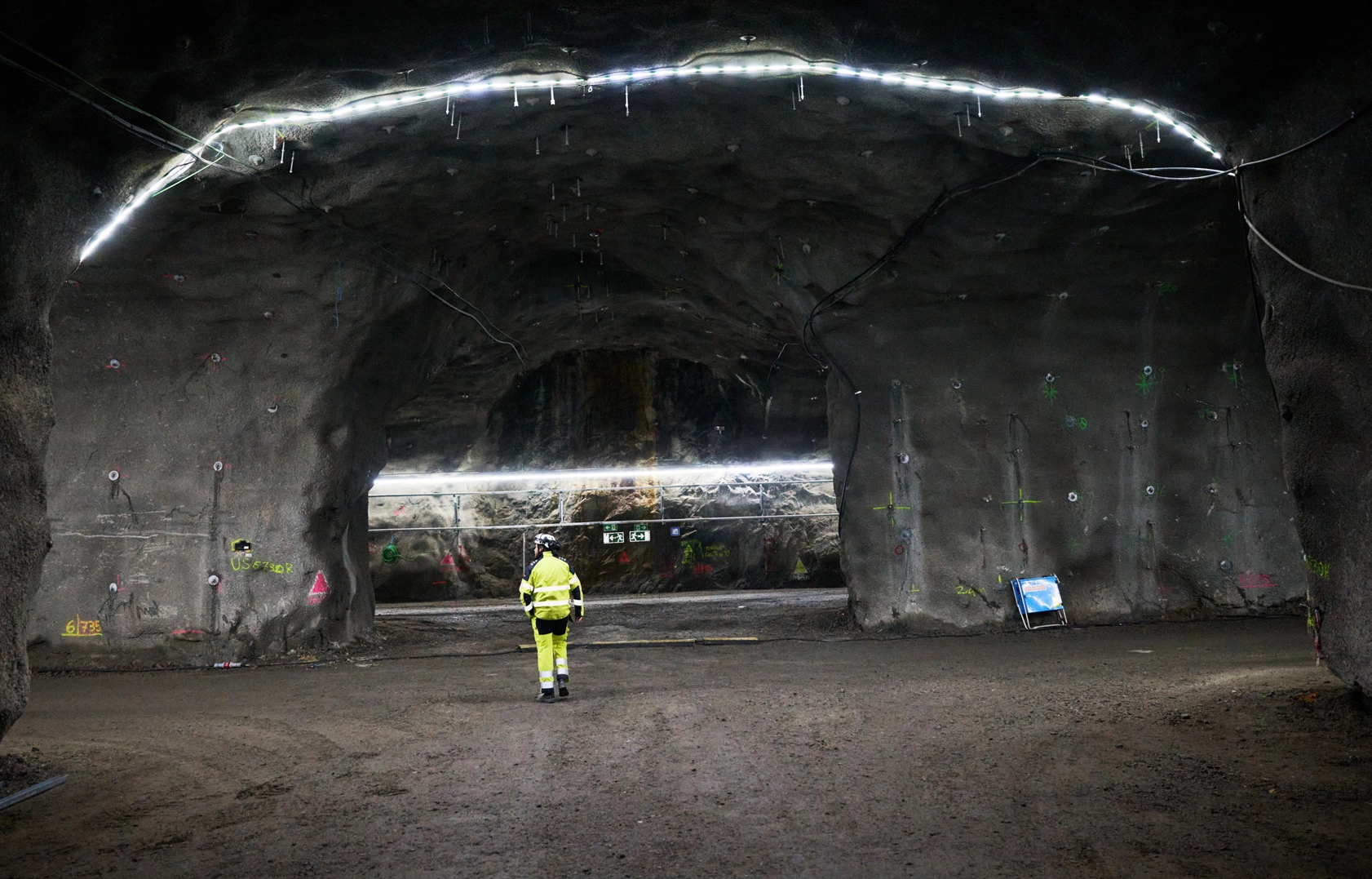 En medarebtera från bolaget Bygg och Berglaget som går i en grotta.