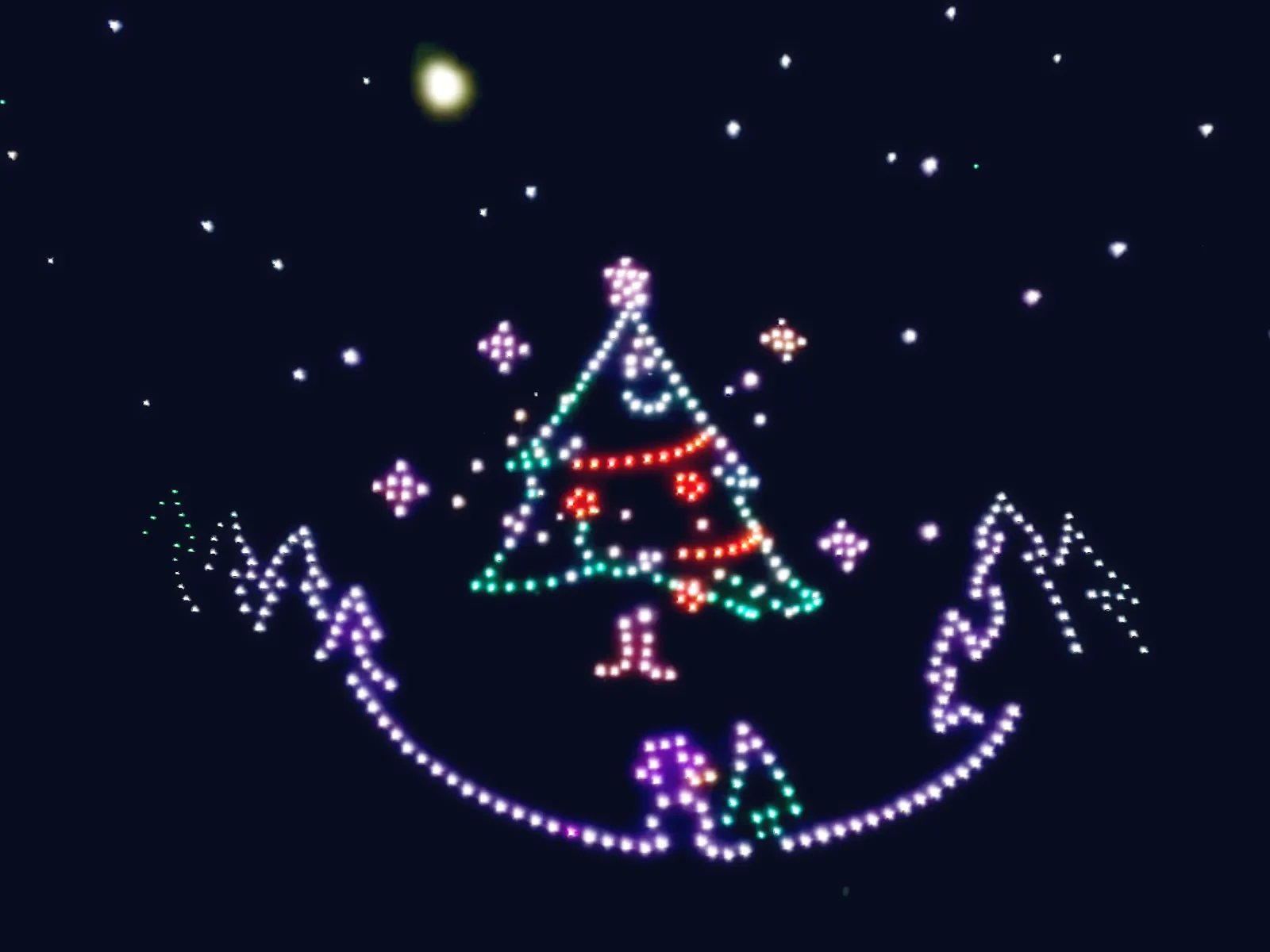 Spectacle de drones Noël : un sapin décoré et des montagnes enneigées dessinés par les drones