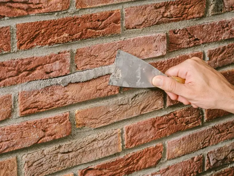 Vakman van De Vries Geveltechniek aan het werk aan een gevel