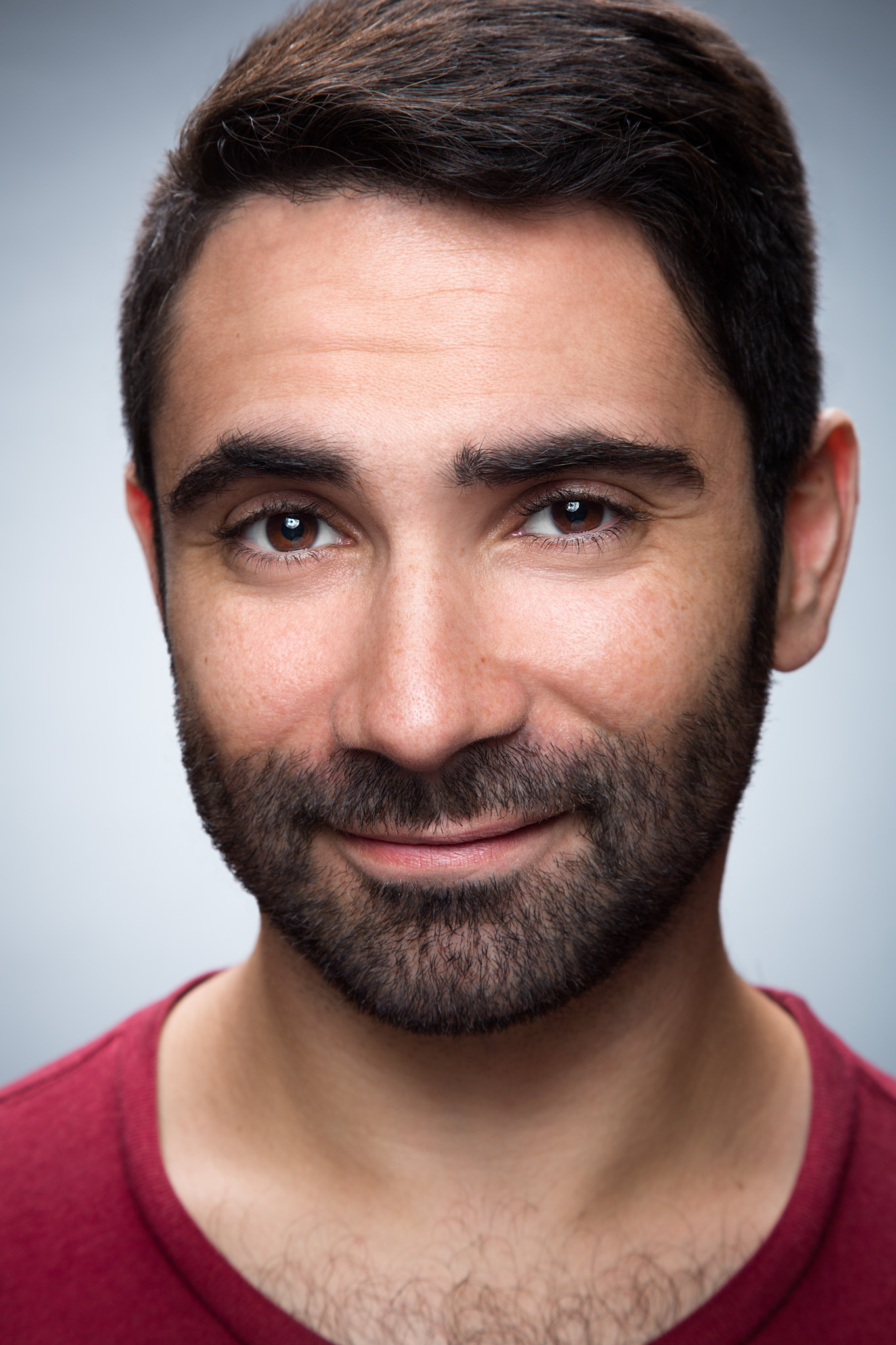 Michael Feld smiling in a red shirt