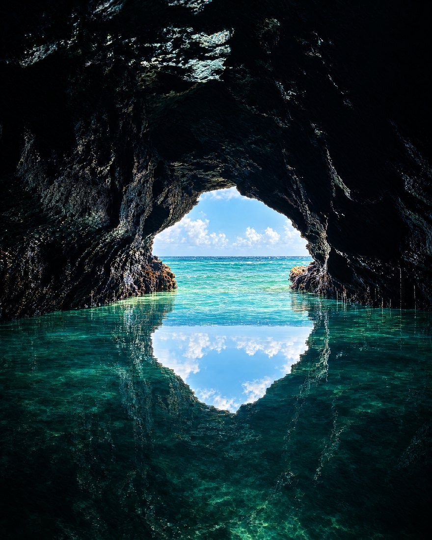 Grotte marine : l’ouverture sur la mer et son reflet forment un œil de lumière