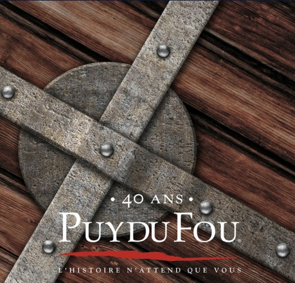 Puy du Fou, 40 ans : un bouclier de bois aux bandes de fer rivetées, en gros plan, le logo et la signature « L’histoire n’attend que vous »