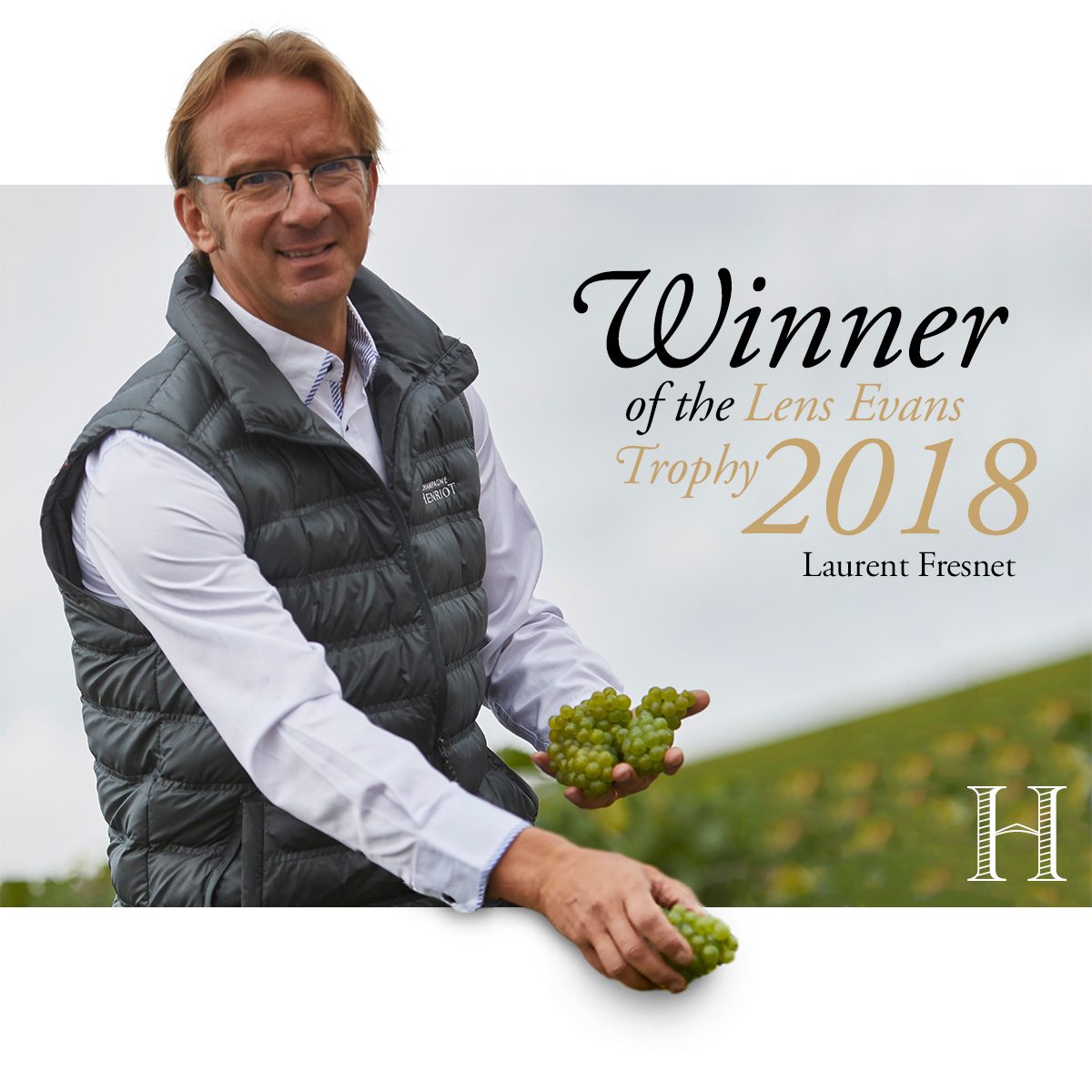 Champagne Henriot : le chef de cave dans les vignes, une grappe à la main, et son trophée de 2018