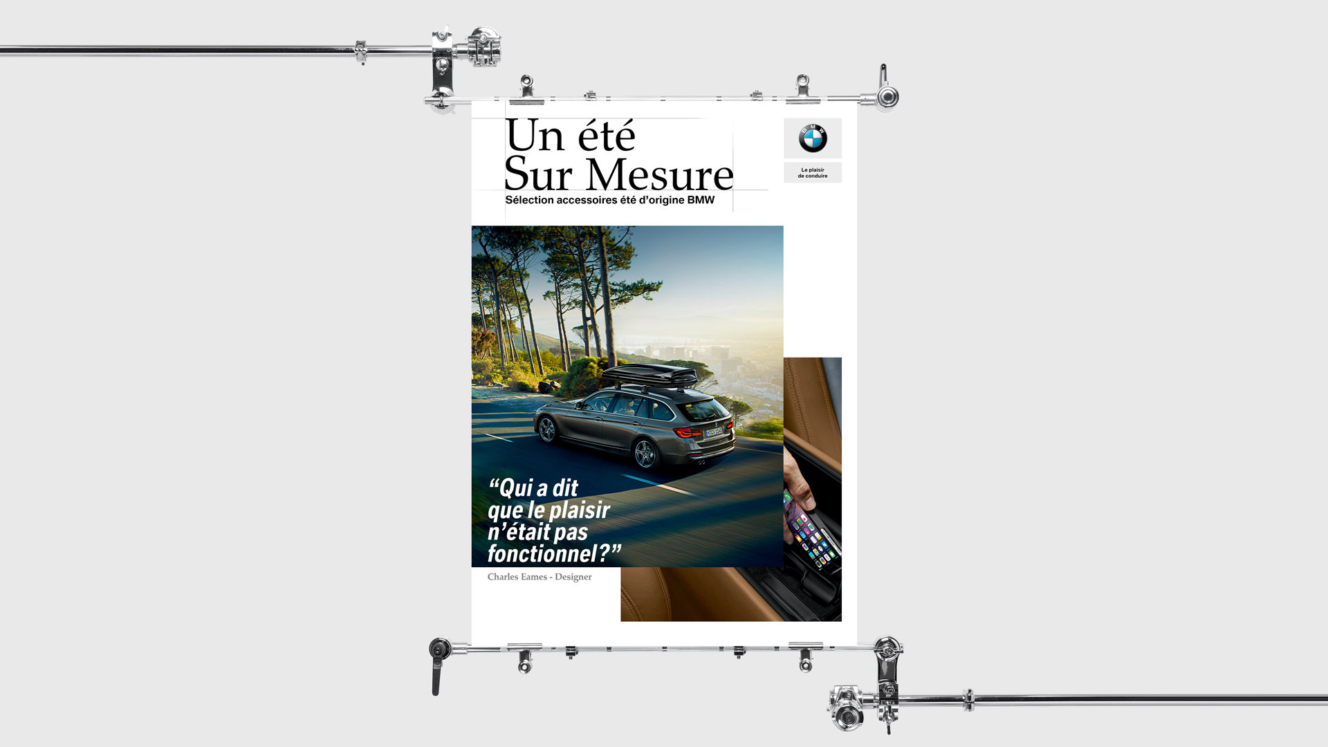 BMW, affiche « Un été sur mesure » : un break BMW avec coffre de toit sur une route bordée de pins, et la citation de Charles Eames