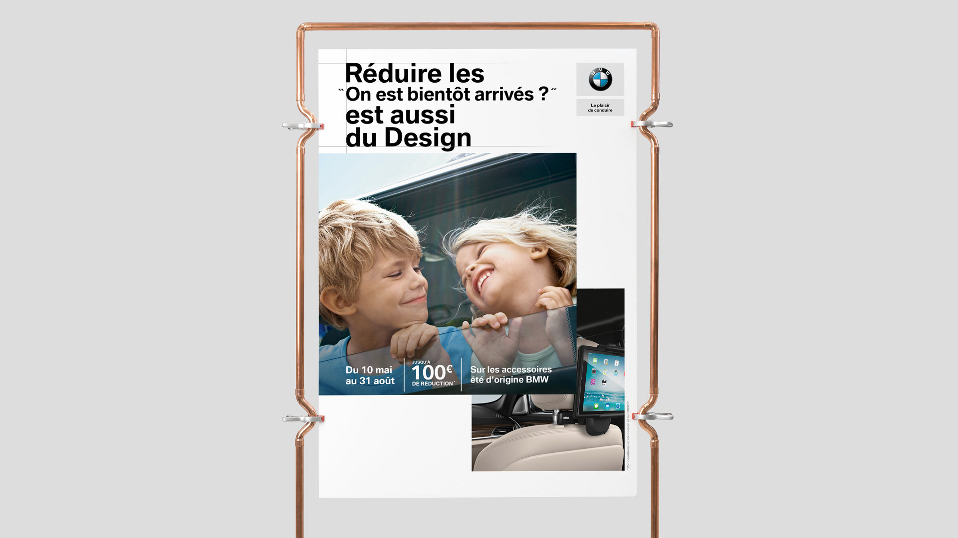 BMW, affiche « Réduire les “On est bientôt arrivés ?” est aussi du design » : deux enfants rient à la vitre, jusqu’à 100 € de réduction du 10 mai au 31 août