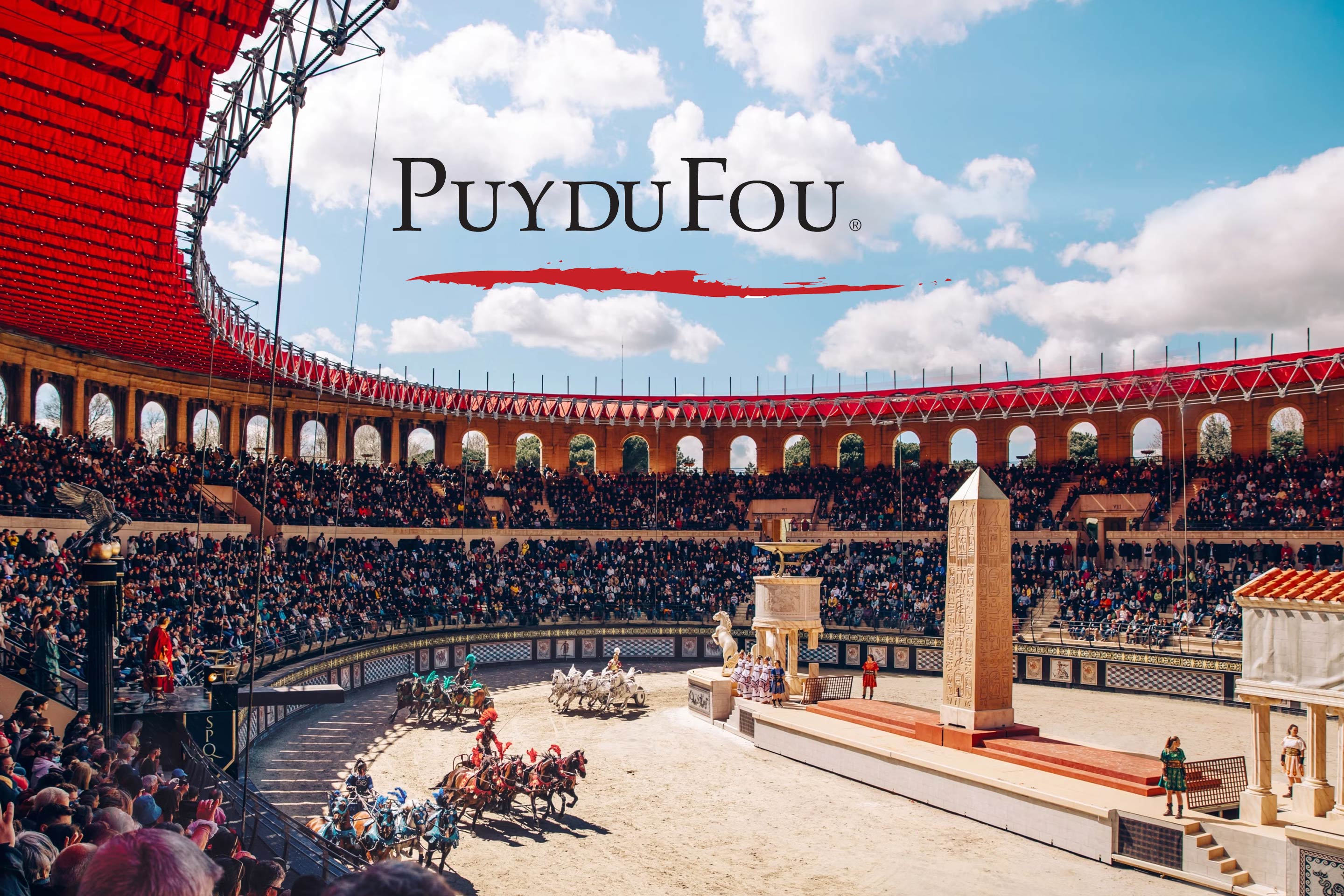 Puy du Fou : son logo au-dessus des gradins combles de l’arène gallo-romaine, pendant une course de chars