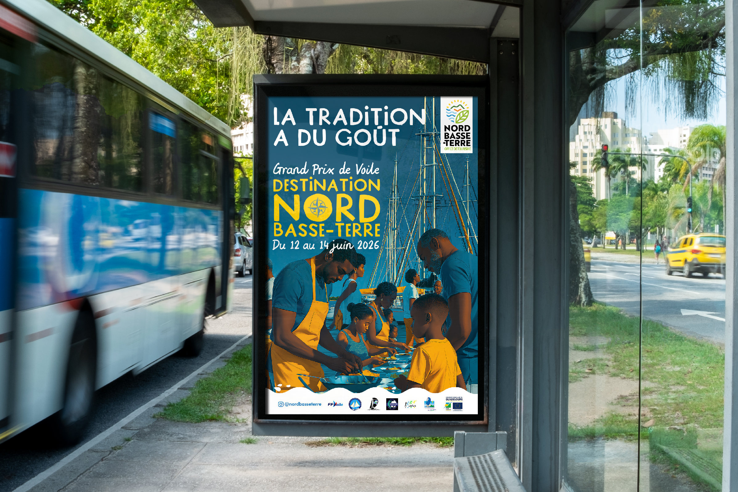 Grand Prix de Voile du Nord Basse-Terre : l’affiche « La tradition a du goût » dans un abribus, une famille qui cuisine devant les mâts des voiliers