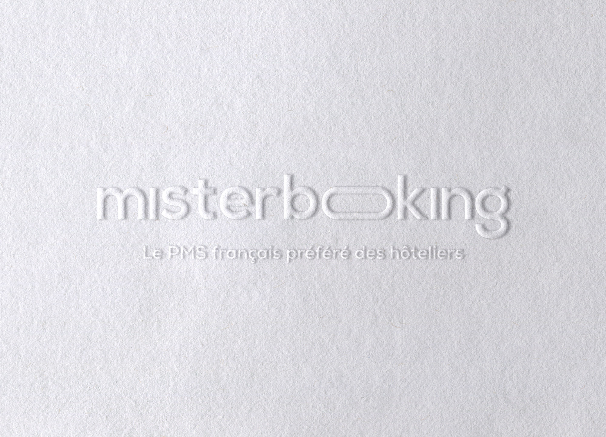 MisterBooking : le logo gaufré sur un papier blanc, avec sa signature « Le PMS français préféré des hôteliers »