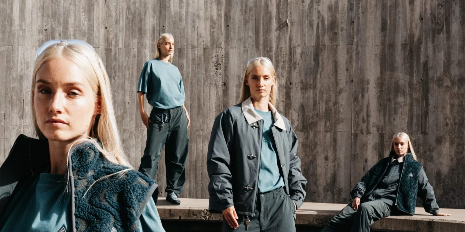 Quatre jeunes femmes blondes posent devant un mur de béton brut, en polaire bouclée, veste à col clair et pantalons larges dans des tons vert sapin et gris bleuté