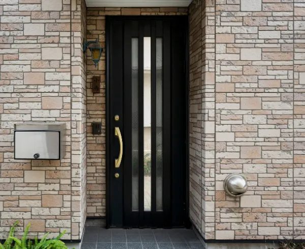 Porte d'entrée grise avec vitre sur maison en pierre