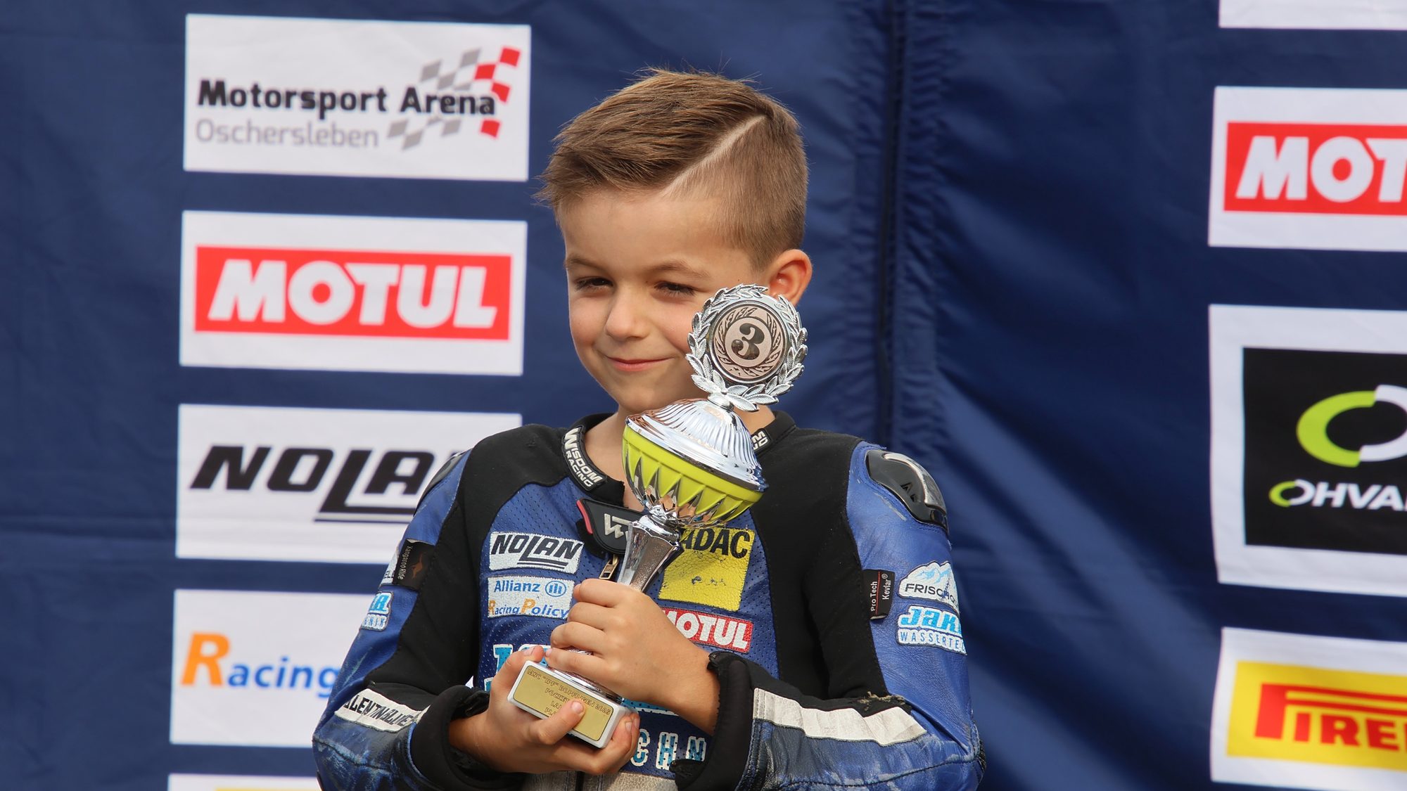 Valentin lächelt bei der Siegerehrung mit seinem Pokal