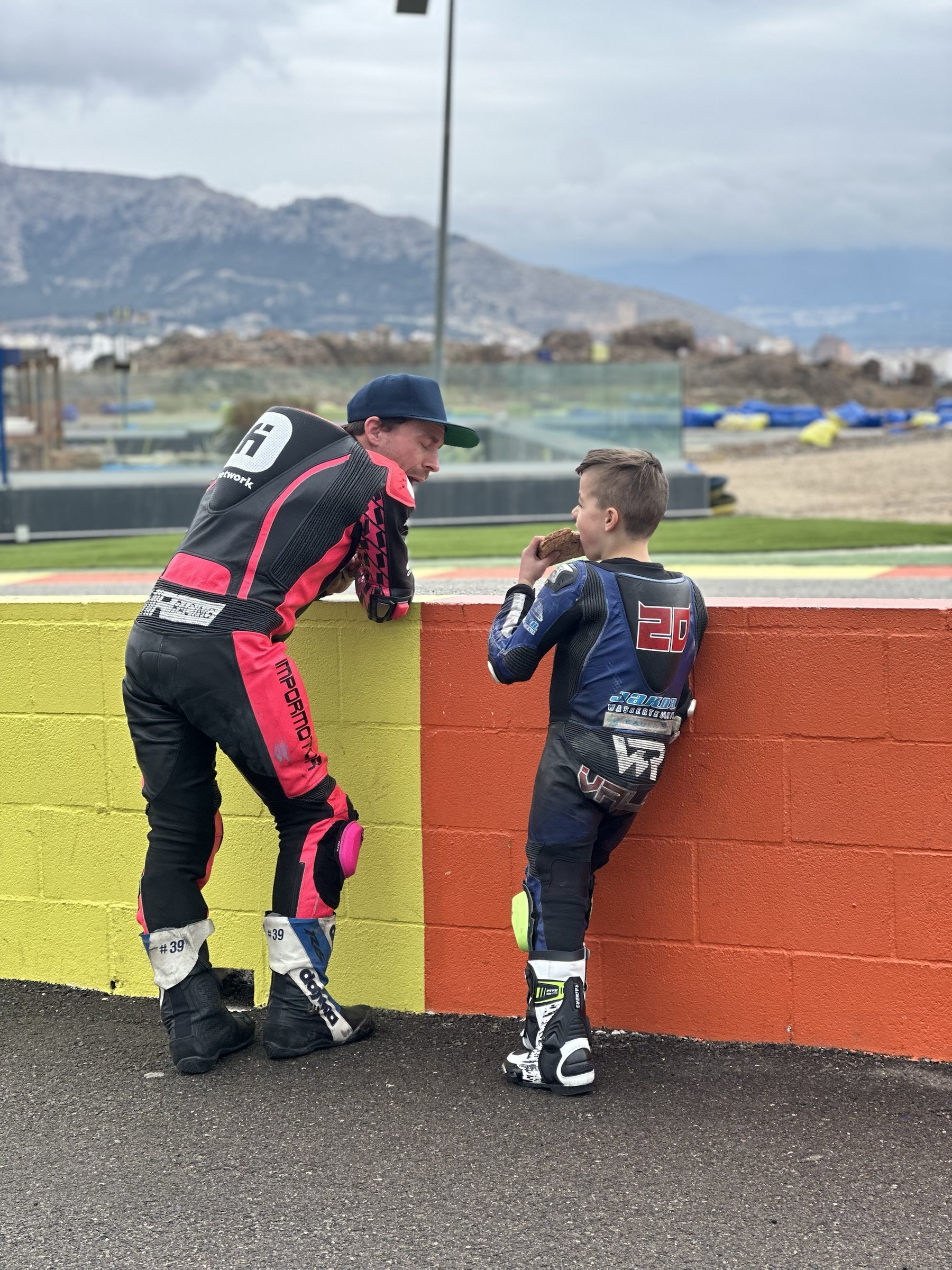 Valentin und Coach Nicky machen Pause an der Streckenmauer, im Hintergrund die spanischen Berge