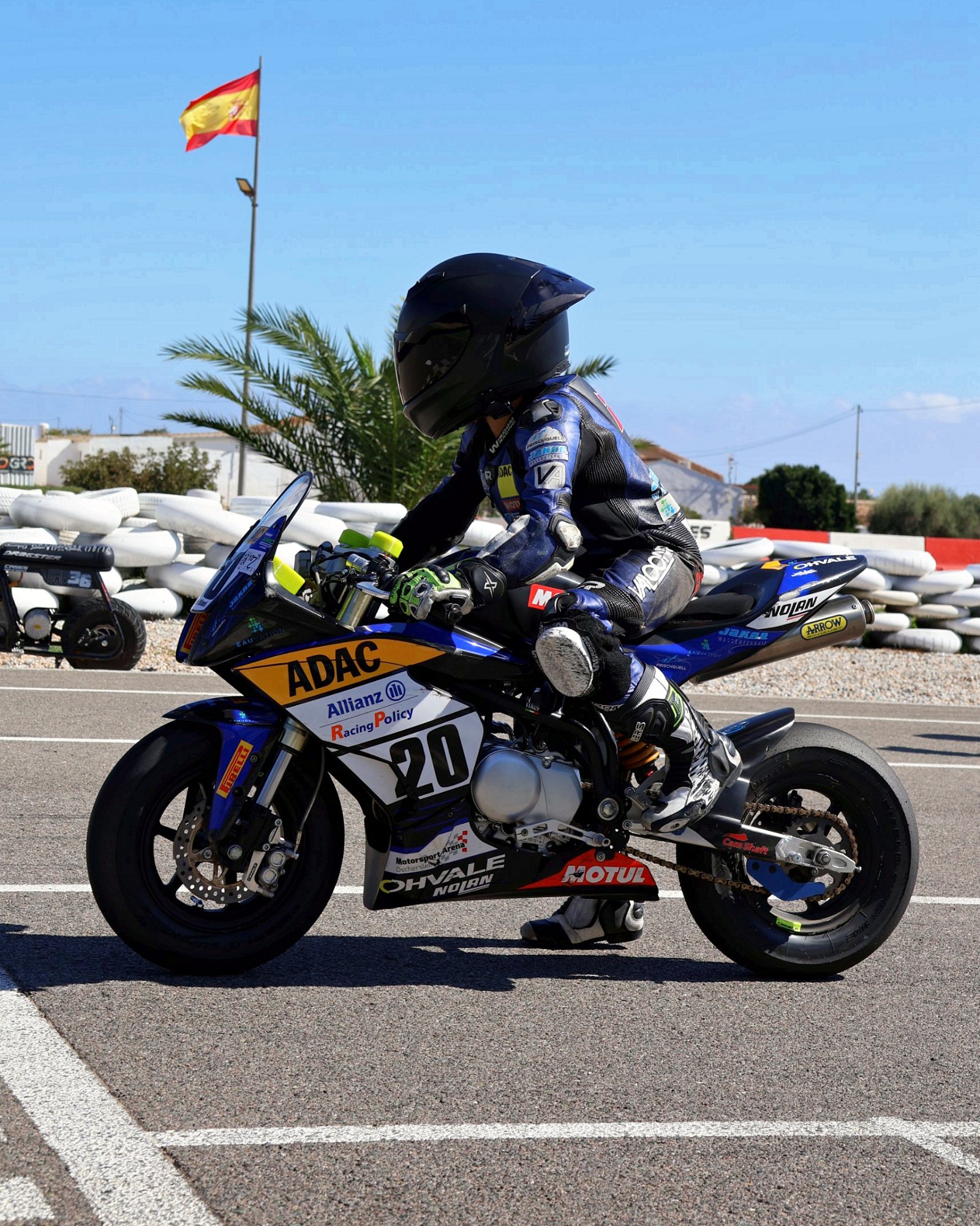 Valentin auf seiner Ohvale mit Startnummer 20 und den Logos der Partner, im Hintergrund die spanische Flagge