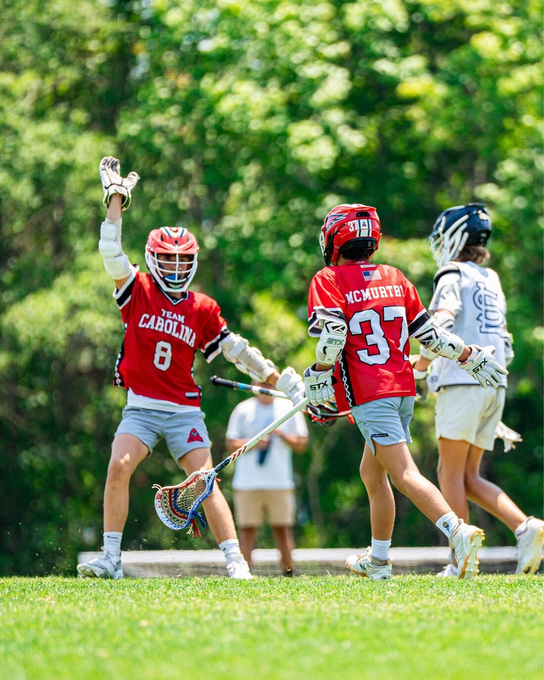 Youth lacrosse players celebrating on the field