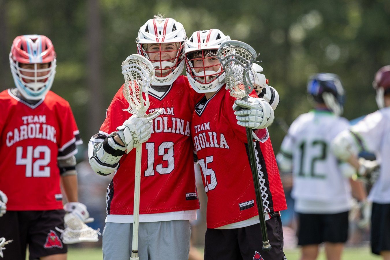 Team Carolina boys lacrosse players celebrating a goal