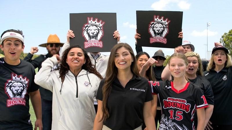 Young athletes and families cheering at a Signature community event