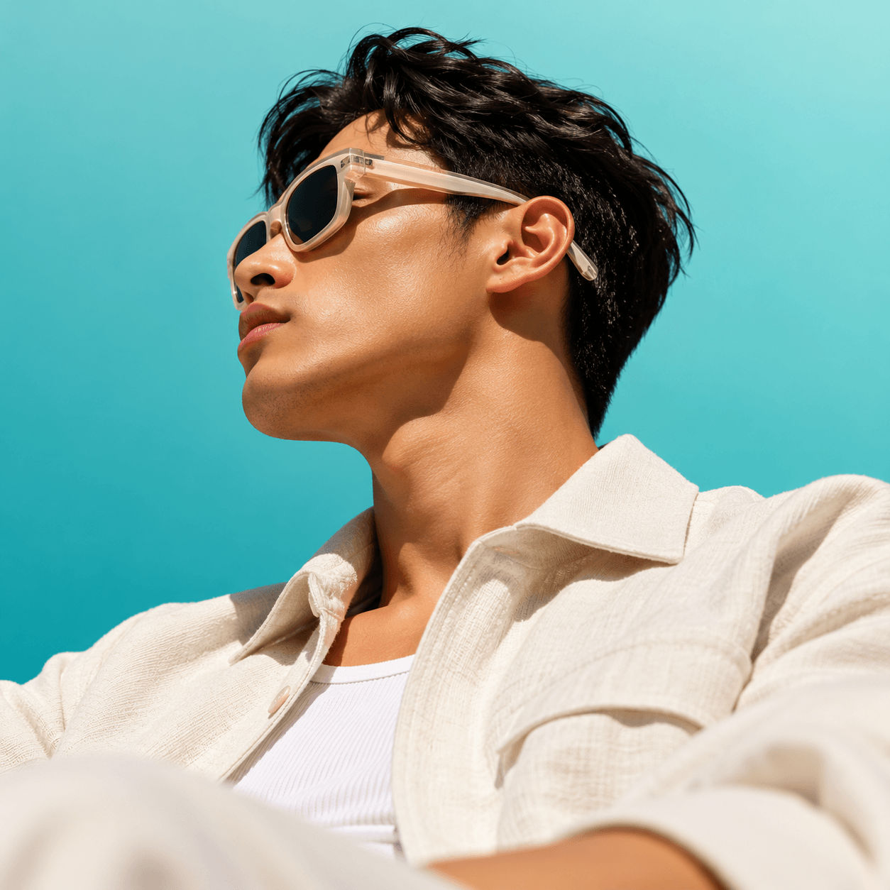 Man in sunglasses and a linen shirt against a blue sky