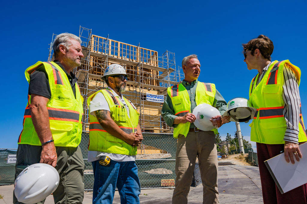 Scott Peters in a hard hat touring a San Diego housing construction site with workers