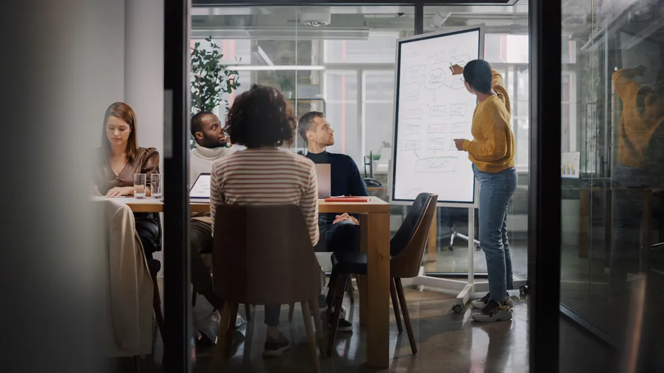 Team meeting in a glass-walled conference room.