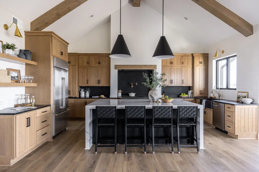 Remodeled kitchen with wood cabinets, a large island, and pendant lights.