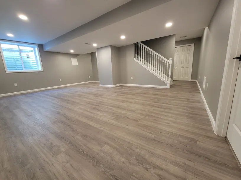 Finished basement with new flooring and recessed lighting.