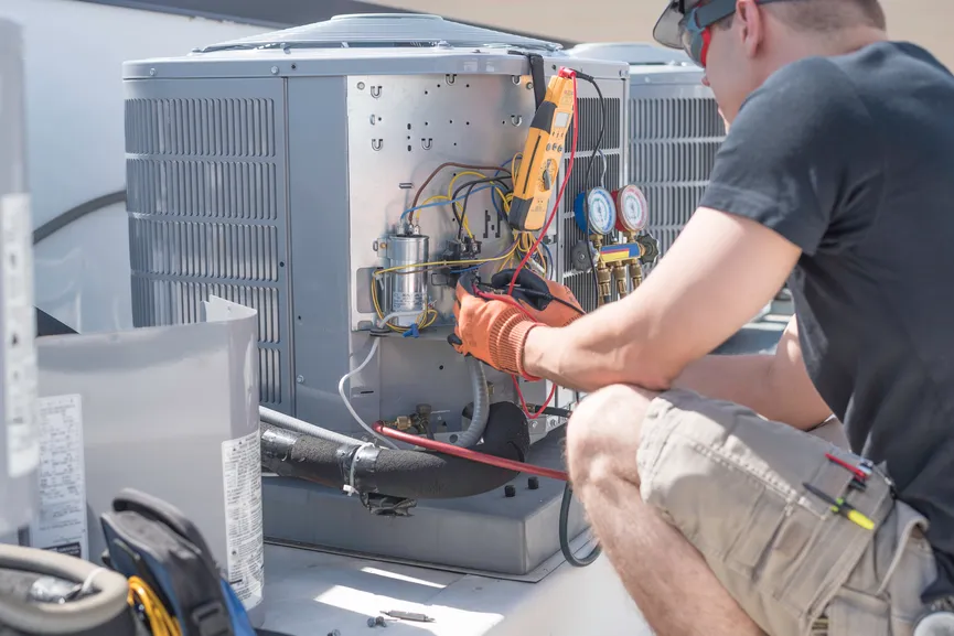 HVAC technician servicing an outdoor air conditioning unit.