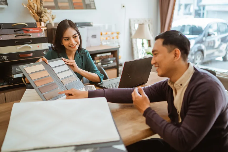 Consultant showing fabric samples to a client at a table.