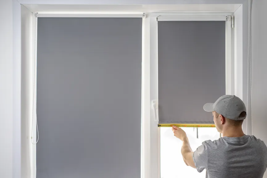 Installer measuring a window for a roller shade.