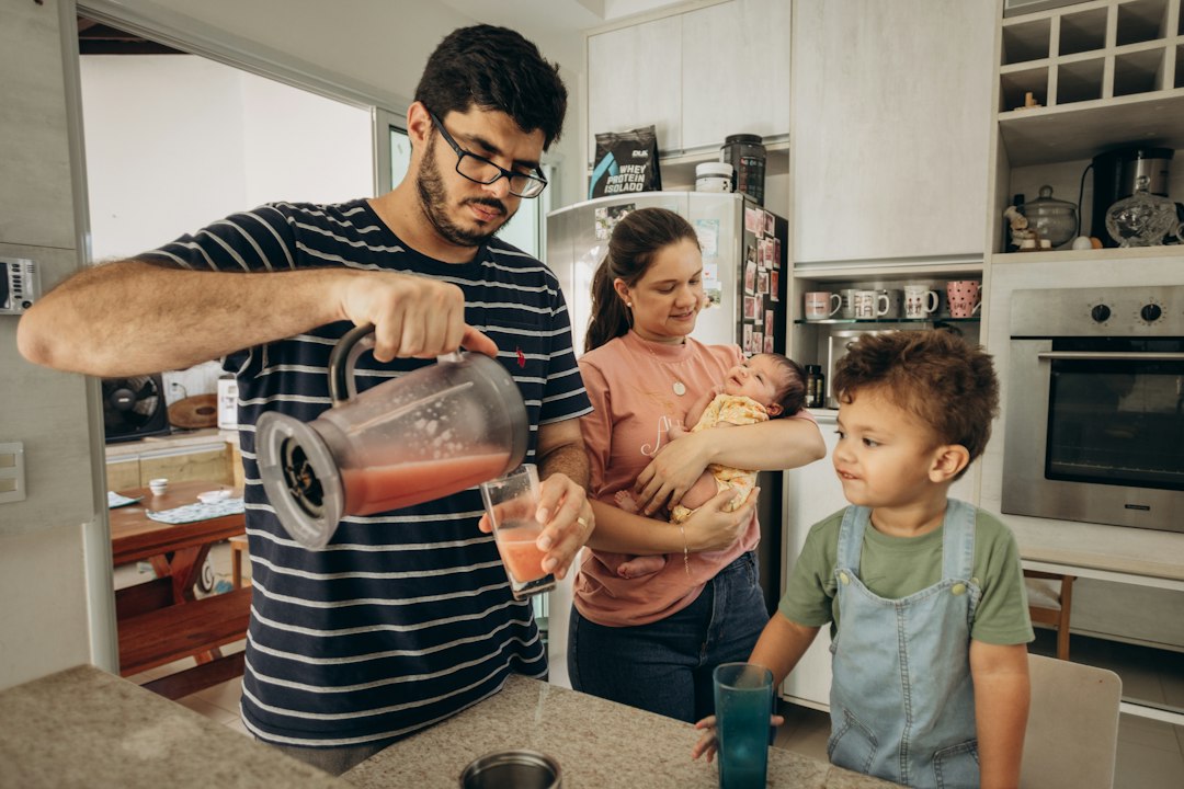 family using hot water in a kitchen to wash dishes - what size water heater does your home need